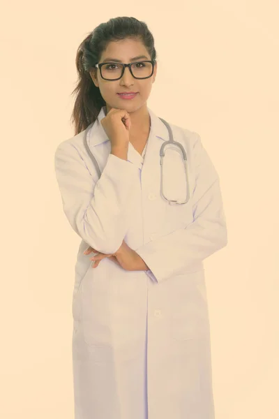 Studioaufnahme einer jungen schönen persischen Ärztin, die mit einer vor weißem Hintergrund isolierten Brille denkt — Stockfoto