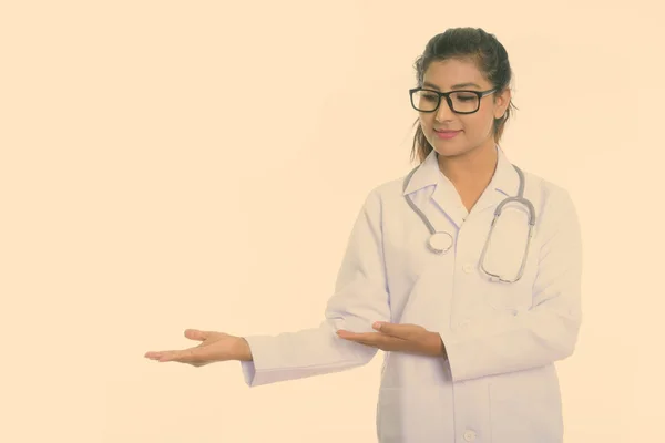 Estúdio tiro de jovem bela mulher persa médico mostrando algo isolado contra fundo branco — Fotografia de Stock