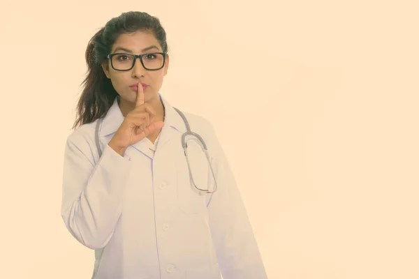 Estúdio tiro de jovem bela mulher persa médico com o dedo em lábios isolados contra fundo branco — Fotografia de Stock