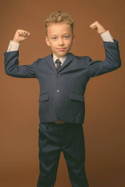 Giovane ragazzo come uomo d'affari contro sfondo marrone — Foto Stock