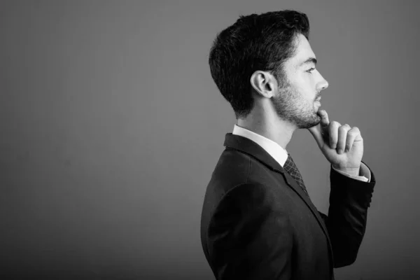 Giovane uomo d'affari bello in giacca e cravatta contro sfondo grigio — Foto Stock