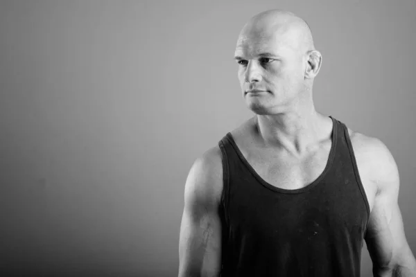 Bald muscular man wearing tank top against gray background — Stock Photo, Image