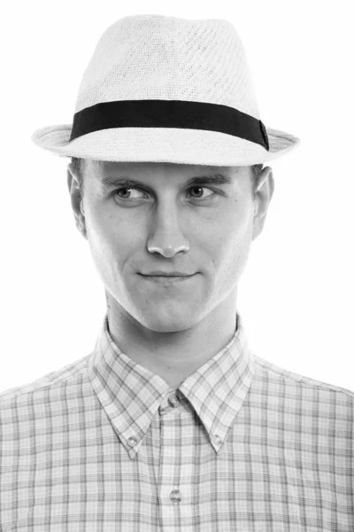 Rosto de homem bonito jovem pensando e olhando para a distância, enquanto vestindo chapéu — Fotografia de Stock