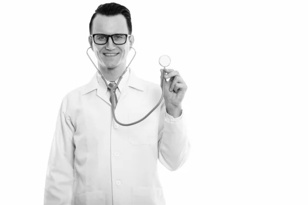 Estudio de tiro de joven feliz hombre médico sonriendo mientras se utiliza estetoscopio — Foto de Stock