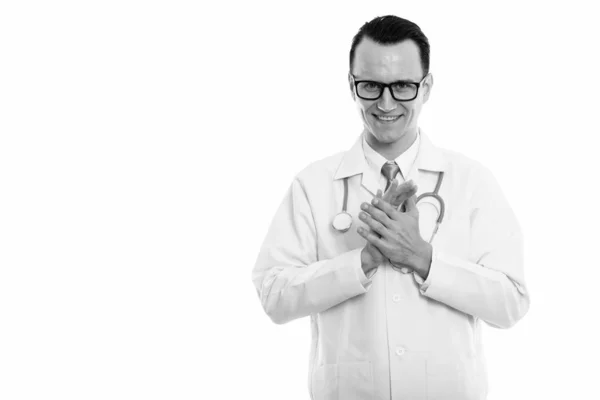 Студійний знімок молодого щасливого лікаря, який посміхається, потираючи руки разом — стокове фото