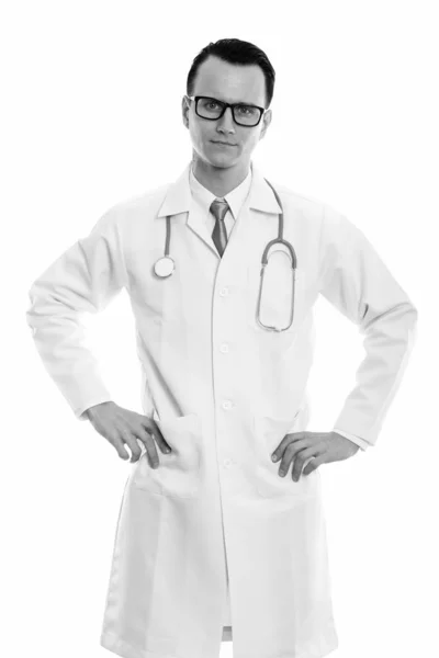 Студійний знімок молодого красивого чоловіка лікаря, що стоїть руками на стегнах — стокове фото