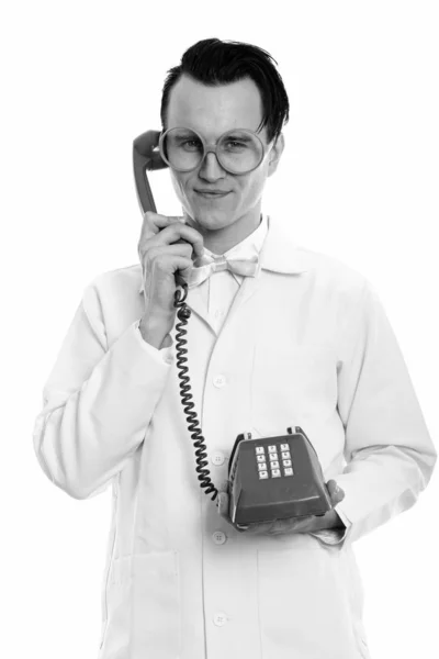 Studio shot van gekke jongeman arts houdt oude telefoon — Stockfoto