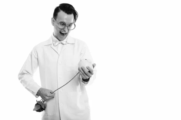 빨간 돼지 저금통 안에 장미를 찔 러 하는 동안 웃 고 행복 한 미친 남자 의사의 스튜디오 촬영 — 스톡 사진