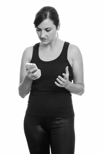 Estudio de la mujer enojada sosteniendo el teléfono móvil —  Fotos de Stock
