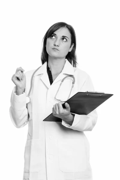 Studio záběr lékaře krásná žena držící schránky při myšlení — Stock fotografie