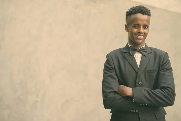 Joven hombre de negocios africano guapo usando traje contra la pared de hormigón al aire libre —  Fotos de Stock
