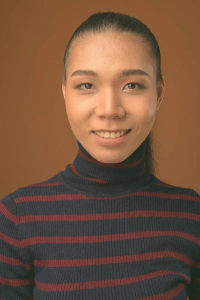 Jovem bela mulher transexual asiática contra fundo marrom — Fotografia de Stock