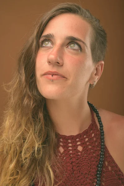Junge schöne hispanische Frau vor braunem Hintergrund — Stockfoto
