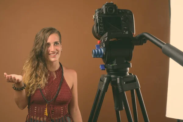 Jonge mooie Spaanse vrouw tegen bruine achtergrond — Stockfoto