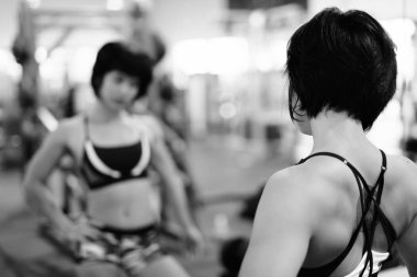 Genç güzel Asyalı kadın spor salonunda egzersiz