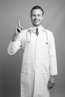 Gri arka planda yakışıklı doktor portresi