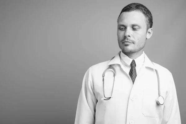 Retrato de homem bonito médico contra fundo cinza — Fotografia de Stock