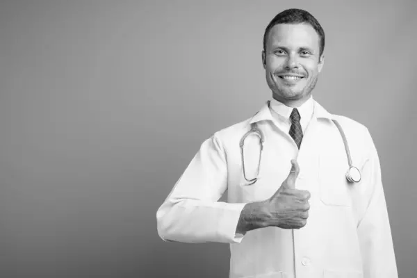 Portrait of handsome man doctor against gray background — Stock Photo, Image