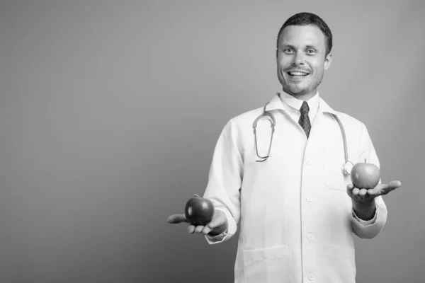 Portret van knappe man arts tegen grijze achtergrond — Stockfoto