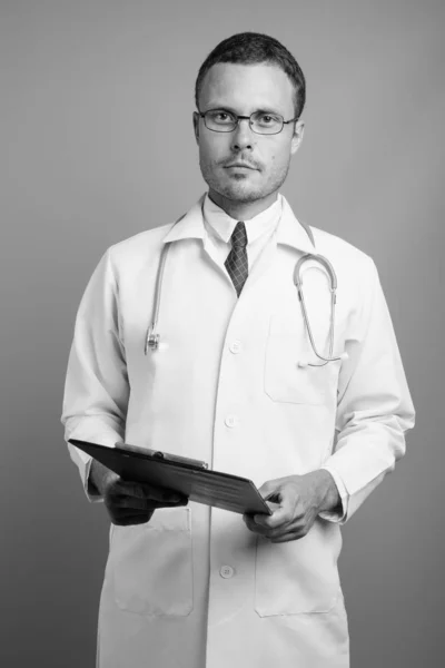 Porträt eines gutaussehenden Arztes vor grauem Hintergrund — Stockfoto