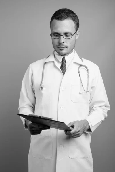 Portrait of handsome man doctor against gray background — Stock Photo, Image