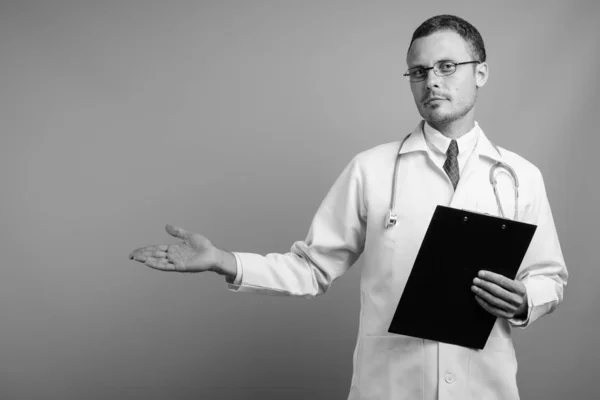 Portrait of handsome man doctor against gray background — Stock Photo, Image