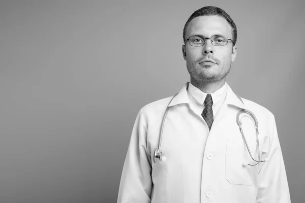 Portret van knappe man arts tegen grijze achtergrond — Stockfoto