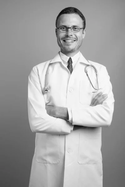 Retrato de homem bonito médico contra fundo cinza — Fotografia de Stock