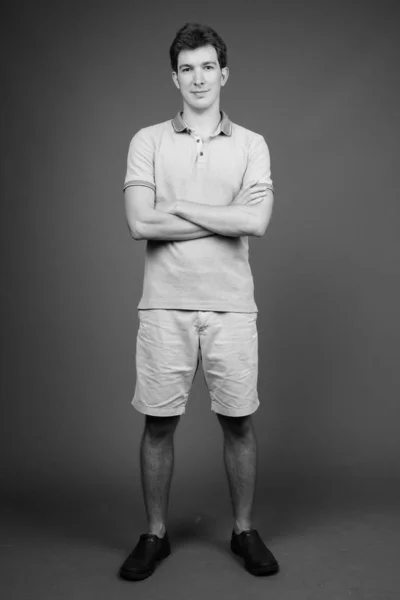 Portret van jonge knappe man tegen grijze achtergrond — Stockfoto