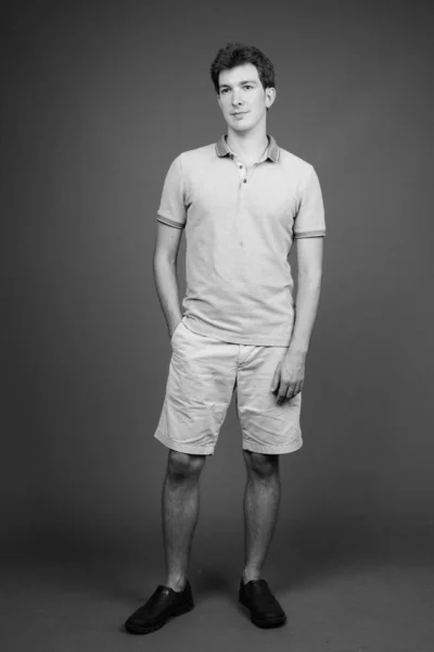 Portrait of young handsome man against gray background — Stock Photo, Image