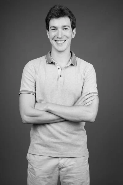 Retrato de homem bonito jovem contra fundo cinza — Fotografia de Stock