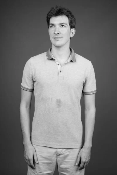 Retrato de homem bonito jovem contra fundo cinza — Fotografia de Stock