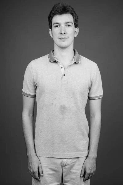 Portret van jonge knappe man tegen grijze achtergrond — Stockfoto