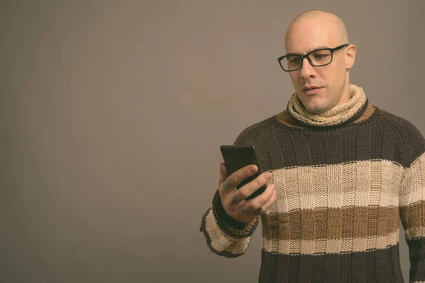 Portrait of handsome bald man against gray background