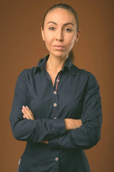 Studio shot of young beautiful businesswoman against brown background — Stock Photo, Image