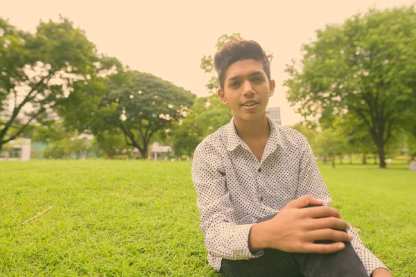 Retrato de jovem adolescente indiano relaxante no parque — Fotografia de Stock