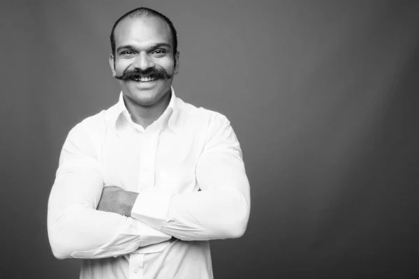 Indian businessman with mustache against gray background — стокове фото