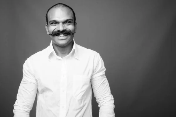 Indian businessman with mustache against gray background — стокове фото