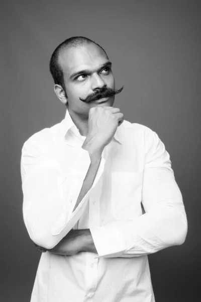 Indian businessman with mustache against gray background — стокове фото