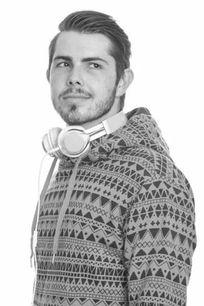 Joven guapo hombre caucásico pensando mientras usa auriculares alrededor del cuello — Foto de Stock