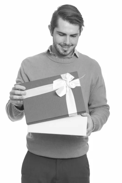 Молодой кавказский мужчина открывает подарочную коробку на день святого Валентина — стоковое фото