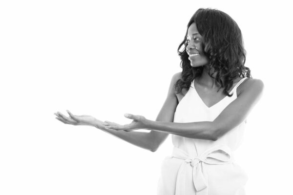 Studio shot of young African woman wearing wig isolated against white background in black and white