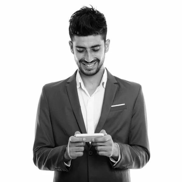 스튜디오에서 젊고 행복 한 페르시아 사업가가 휴대폰을 사용하면서 웃고 있는 모습 — 스톡 사진