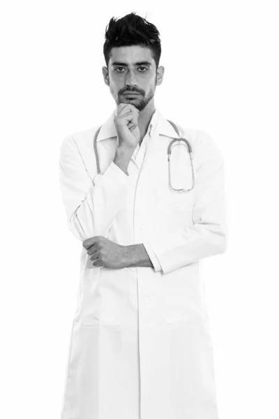 Studio shot of young Persian man doctor standing and thinking — Stock Photo, Image