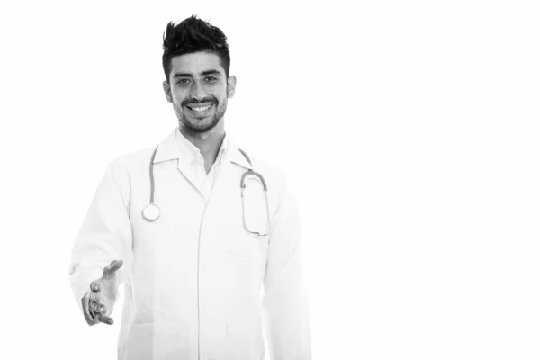 Studio shot of young happy Persian man doctor smiling while giving handshake — Stock Photo, Image