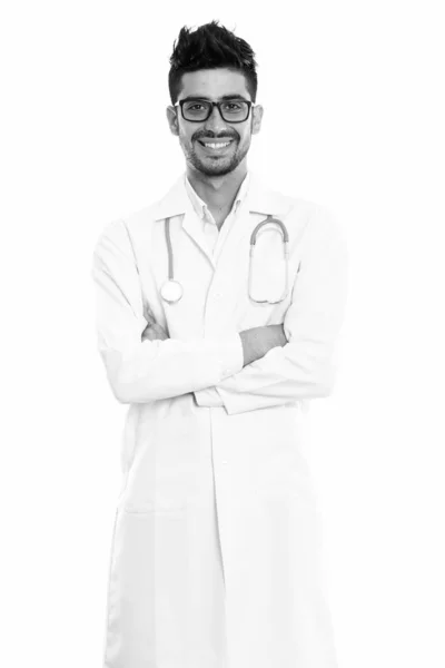 Studio shot of young happy Persian man doctor smiling and standing with arms crossed — Stock Photo, Image