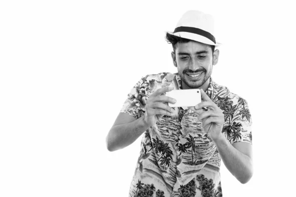 携帯電話で写真を撮影しながら笑みを浮かべて若い幸せなペルシャ観光客男のスタジオ撮影 — ストック写真
