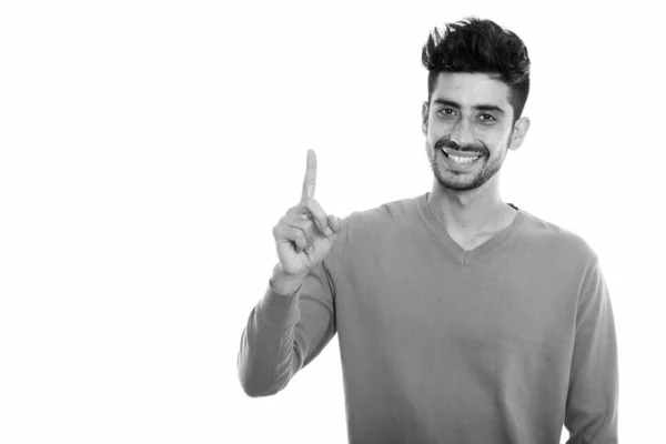Estúdio tiro de jovem feliz persa homem sorrindo enquanto apontando o dedo para cima — Fotografia de Stock