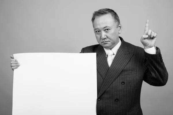 Studio Shot Mature Asian Businessman Holding White Board Gray Background — Foto Stock