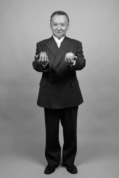 Studio Shot Mature Asian Businessman Holding Apple Gray Background Black — Stockfoto